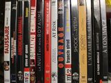 a lot of dvds that are stacked up on a shelf
