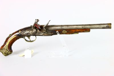 an old gun that is on display on a white surface