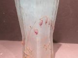 a glass vase with flowers on it sitting on a table