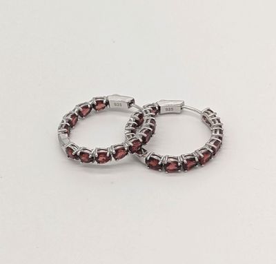une paire de boucles d'oreilles créoles en argent ornées de grenats