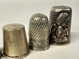 three silver thimbles sitting next to each other on a white surface