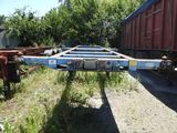 une remorque qui est garée dans l'herbe à côté d'un train