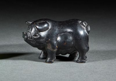 une petite statue représentant un cochon, posée sur une table