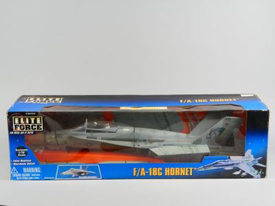 maquette d'un avion de chasse dans une boîte, posée sur une surface blanche