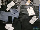 several pairs of black jeans and a leopard print shirt are on display