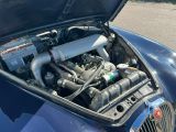 une voiture bleue dont le capot est ouvert et dont le moteur se trouve dans le coffre