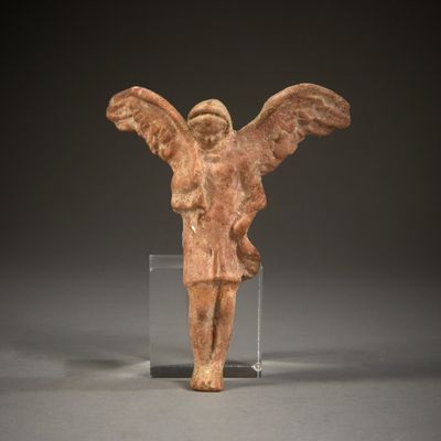 an ancient figurine of an angel with wings