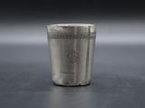 a close up of a silver shot glass on a table