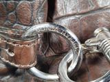 a close up of a leather purse with a metal ring