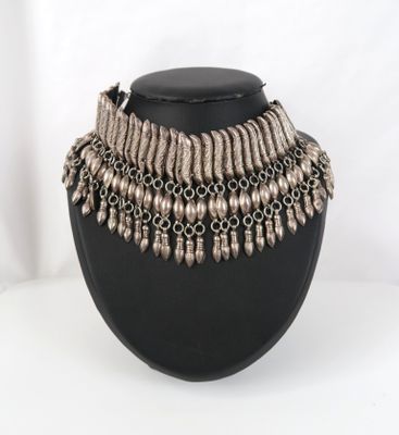 un collier noir orné de perles argentées sur un mannequin noir