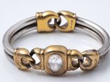 une photo en gros plan d'un bracelet en argent et en or