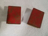 deux petits livres rouges posés sur une surface blanche