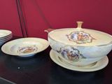 many plates and bowls on a table with a red wall in the background