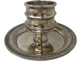 an antique silver plate with a candle holder on it