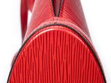 the back end of a red suitcase on a white surface