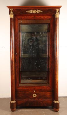 une vitrine ancienne en bois, dotée d'une porte vitrée et de garnitures dorées