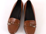 tan leather loafers with metal buckles on the toes