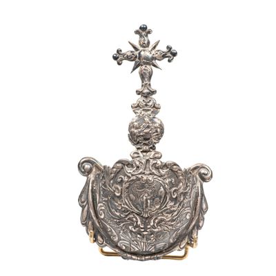 un plat en argent richement décoré, surmonté d'une croix