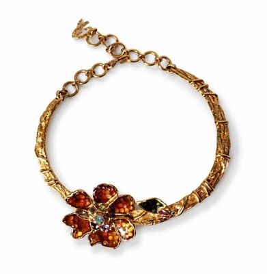 a close up of a gold bracelet with flowers on it