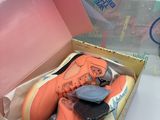 a box with a pair of orange shoes in it