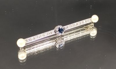 deux broches ornées de perles et de diamants sur un fond noir