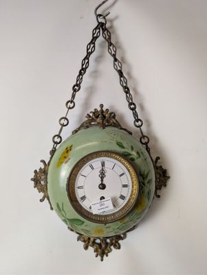 a clock hanging from a chain on the wall