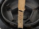 a close up of a dirty helmet with a piece of paper sticking out of it