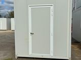 une photo représentant des toilettes portables blanches dans un parking