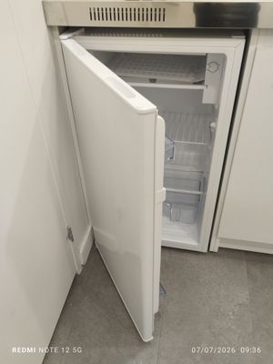 an open refrigerator in the corner of a kitchen