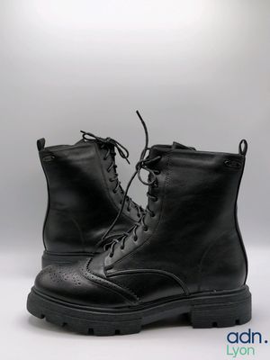black leather boots with laces and rubber soles on a white background