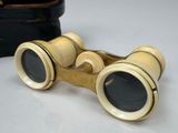 a pair of binoculars sitting on a table next to a suitcase