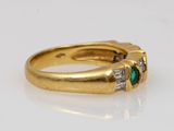 a close up of a gold ring with two emerald stones