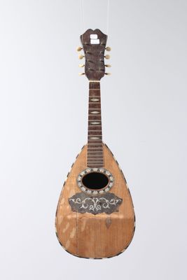 a guitar hanging from a string on a white wall
