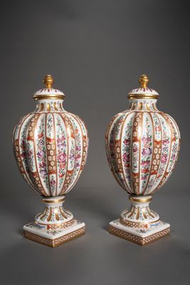 paire de vases chinois ornés de motifs floraux, posés sur des socles, sur fond gris