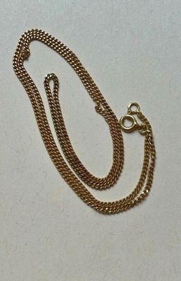 Collier à chaîne en plaqué or avec un fermoir et un fermoir sur fond blanc