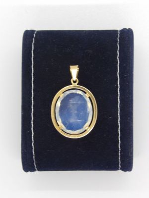 un gros plan sur une pierre bleue sertie dans un pendentif plaqué or