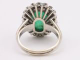 a close up of a ring with a green stone in it