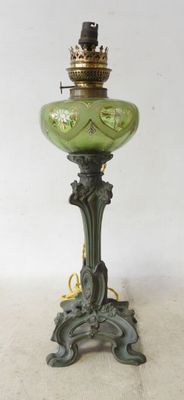 an antique green glass lamp with a crown on top of it