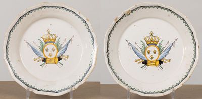 deux assiettes ornées d'une couronne et de deux épées, posées sur une table