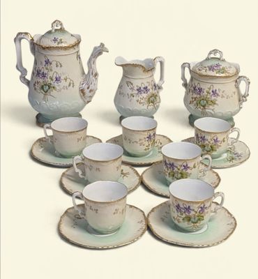 plusieurs tasses et soucoupes et une théière sur la table