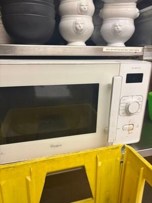 un micro-ondes posé sur un bac jaune