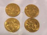four gold sovereigns on a white background