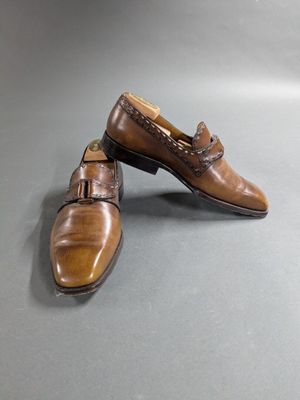 pair of men ' s brown leather shoes on a gray surface