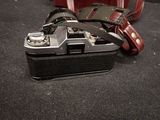 a camera with a strap attached to it sitting on the floor