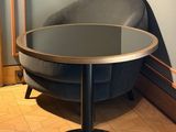 a round table with a glass top on a wooden floor