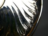 a close up of a silver vase with a black background