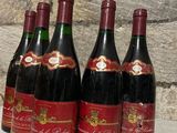 six bottles of red wine are lined up in a row