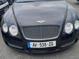 bentley car in parking lot with cars parked in the background