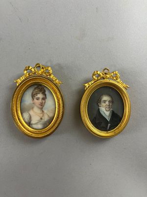 two miniature portraits of a man and a woman in gold frames