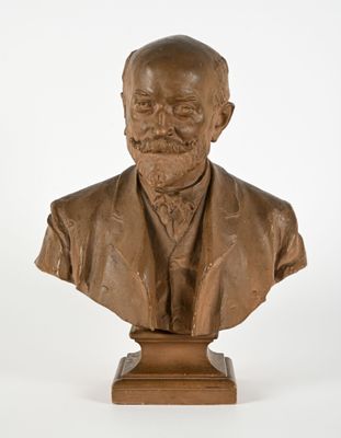 statue représentant le buste d'un homme barbu, posée sur un socle en bois